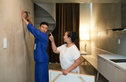 cheerful-asian-handyman-hammering-nail-female-homeowner-giving-instructions_1098-17849